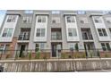 Townhome exterior with a gray facade, balconies, and landscaped front yard at 8711 E Hampden Ave # 23, Denver, CO 80231