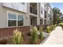 Exterior view of a gray townhome with a landscaped walkway and front door at 8711 E Hampden Ave # 23, Denver, CO 80231