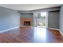 Living room with hardwood floors, a brick fireplace, and sliding doors to a patio at 14204 E 1St Dr # A12, Aurora, CO 80011