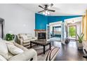 Cozy living room with a stone fireplace, hardwood floors, and plenty of natural light at 10288 Olathe Way, Commerce City, CO 80022