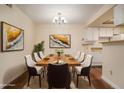 The dining room offers a wooden table with seating for six and decorative paintings at 3412 S Eagle St # 202, Aurora, CO 80014