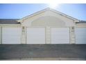 View of white garage doors and parking spaces at 12158 W Dorado Pl # 204, Littleton, CO 80127