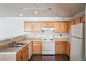 Kitchen featuring wooden cabinets, white appliances and track lighting at 12158 W Dorado Pl # 204, Littleton, CO 80127