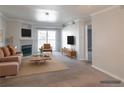 This living room is virtually staged with a seating arrangement centered around a fireplace at 12158 W Dorado Pl # 204, Littleton, CO 80127