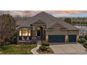 Inviting home exterior featuring stone accents, covered porch, and a three-car garage at 1738 Edgewater Pl, Longmont, CO 80504