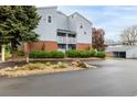 A well-maintained building exterior with brick accents, balconies, mature trees, and convenient parking spaces at 7665 E Eastman Ave # 202A, Denver, CO 80231