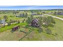 Aerial shot of a charming home with a deck, shed, and fenced yard, nestled amidst lush greenery and mature trees at 3163 Windstream Ln, Elizabeth, CO 80107