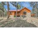 Beautiful log home with stone accents and inviting outdoor area at 23231 Maricopa Rd, Indian Hills, CO 80454