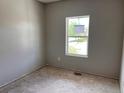 Empty bedroom shows a window overlooking the front yard of the home and awaiting your personal touches at 317 Whimsical Ave, Brighton, CO 80603