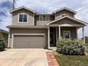 Two-story home with a well-maintained front yard, a two-car garage and neutral-colored siding at 317 Whimsical Ave, Brighton, CO 80603