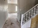 Hallway with view into empty adjacent room; stairs with white railings leading to the second story at 317 Whimsical Ave, Brighton, CO 80603