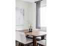 Close up of dining room table setting in a room with grey curtains, artwork, and six chairs at 2862 S Galapago Ct, Englewood, CO 80110