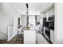 A bright kitchen that flows into the living room, featuring stainless steel appliances and granite island with seating at 2862 S Galapago Ct, Englewood, CO 80110