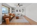 Bright living room featuring a leather couch, a ceiling fan, and built-in shelves at 12017 W 58Th Pl, Arvada, CO 80004