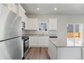 Open kitchen with stainless steel appliances, granite counters, and access to the backyard at 7330 Green River Ave, Frederick, CO 80530