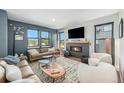 Inviting living room with a cozy fireplace, large windows, and stylish furniture at 941 Saint Andrews Ln, Louisville, CO 80027