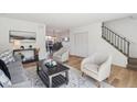 Open-concept living space flowing into dining, featuring hardwood floors and contemporary decor at 3855 S Monaco St # 182, Denver, CO 80237