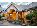 Charming front entrance with stone accents, a custom wooden door, and lush landscaping at 1426 Rembrandt Rd, Boulder, CO 80302