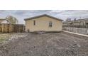 Exterior backyard featuring gravel, partial fencing, and small home elevation at 130 Elm St, Hudson, CO 80642