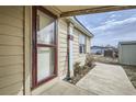 Exterior angle shot featuring tan home elevation with front window, door, and sidewalk at 130 Elm St, Hudson, CO 80642