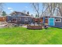 Spacious backyard featuring a brick patio, fire pit, pond and lush green lawn for outdoor enjoyment at 1325 S Ivy Way, Denver, CO 80224