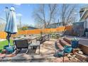 Paver patio with a built-in fire pit, outdoor seating, and a serene pond, ideal for entertaining at 1325 S Ivy Way, Denver, CO 80224