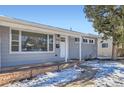 Front view of a Ranch style home with gray siding, white trim, and a stone base at 1040 Hoover Ave, Fort Lupton, CO 80621