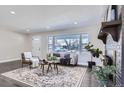 Bright and airy living room with hardwood floors, fireplace, and large windows at 1040 Hoover Ave, Fort Lupton, CO 80621