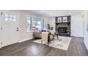 Living room features a fireplace, large windows, and a neutral color palette at 1040 Hoover Ave, Fort Lupton, CO 80621