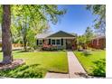 Inviting single-story home boasts a lush lawn, mature trees, and a welcoming walkway at 860 Magnolia St, Denver, CO 80220