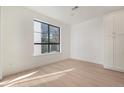 Bright bedroom with large window, hardwood floors, and built-in white cabinets at 2032 S Holly St # 3, Denver, CO 80222