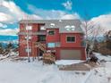 Exterior view of this multi-story home featuring an attached garage and a large driveway at 13589 Callae Ct, Conifer, CO 80433