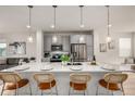 Modern kitchen featuring a large island with seating, stainless steel appliances, and pendant lighting at 2052 Alcott Way, Broomfield, CO 80023