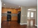Functional kitchen with wooden cabinets, black appliances and hardwood floors at 20630 E Hamilton Ave, Aurora, CO 80013