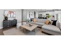 Bright living room featuring a comfortable sofa, modern decor, and hardwood flooring at 17969 Sky Pilot Ave, Parker, CO 80134