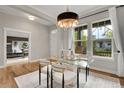 Bright dining room features hardwood floors, contemporary chandelier, and large windows at 8056 E 35Th Ave, Denver, CO 80238