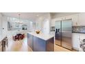 Open-concept kitchen with island, stainless appliances, and view of living room at 7597 Bison Ct, Littleton, CO 80125
