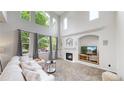 Bright living room with vaulted ceilings, large windows, and a cozy fireplace at 7597 Bison Ct, Littleton, CO 80125