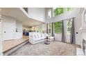 Bright living room open to the kitchen features soaring windows and neutral decor at 7597 Bison Ct, Littleton, CO 80125