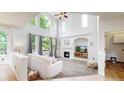 Bright living room with vaulted ceilings, large windows, and a cozy fireplace at 7597 Bison Ct, Littleton, CO 80125