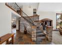 The foyer has a beautiful stone staircase with rod iron details and slate flooring, leading to an upper floor at 34 Amaranth Dr, Littleton, CO 80127