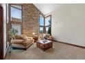Inviting living room showcasing vaulted ceilings, stone accent wall, and large windows offering great natural light at 34 Amaranth Dr, Littleton, CO 80127