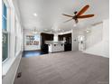 Bright and airy open concept living room and kitchen with dark cabinetry, hardwood floors and large windows at 1826 Sunshine Ave, Longmont, CO 80504
