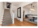 Foyer boasts hardwood floors, a staircase, and a view into dining area with an elegant chandelier at 121 N Marion St, Denver, CO 80218