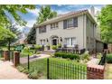 Charming home exterior boasts a well-manicured lawn, black shutters, beautiful landscaping, and inviting front porch at 121 N Marion St, Denver, CO 80218