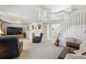 Bright and airy living room showcasing the staircase with a high ceiling and comfortable seating arrangement at 551 Rio Rancho Way, Brighton, CO 80601