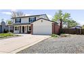 Two-story home with an attached garage and a spacious driveway at 5199 Arbutus St, Arvada, CO 80002