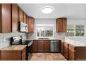 Well-lit kitchen boasts granite countertops, stainless steel appliances, and modern tile backsplash at 5199 Arbutus St, Arvada, CO 80002