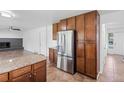 Spacious kitchen with stainless steel refrigerator, granite countertops, and tile flooring at 5199 Arbutus St, Arvada, CO 80002