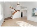 Bright living room with vaulted ceiling, staircase, tile floors, and large windows at 9307 Shadowglen Ct, Highlands Ranch, CO 80126